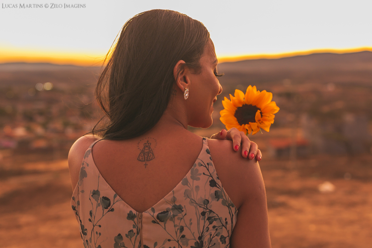 ensaio modelo de costas com girassol na mao