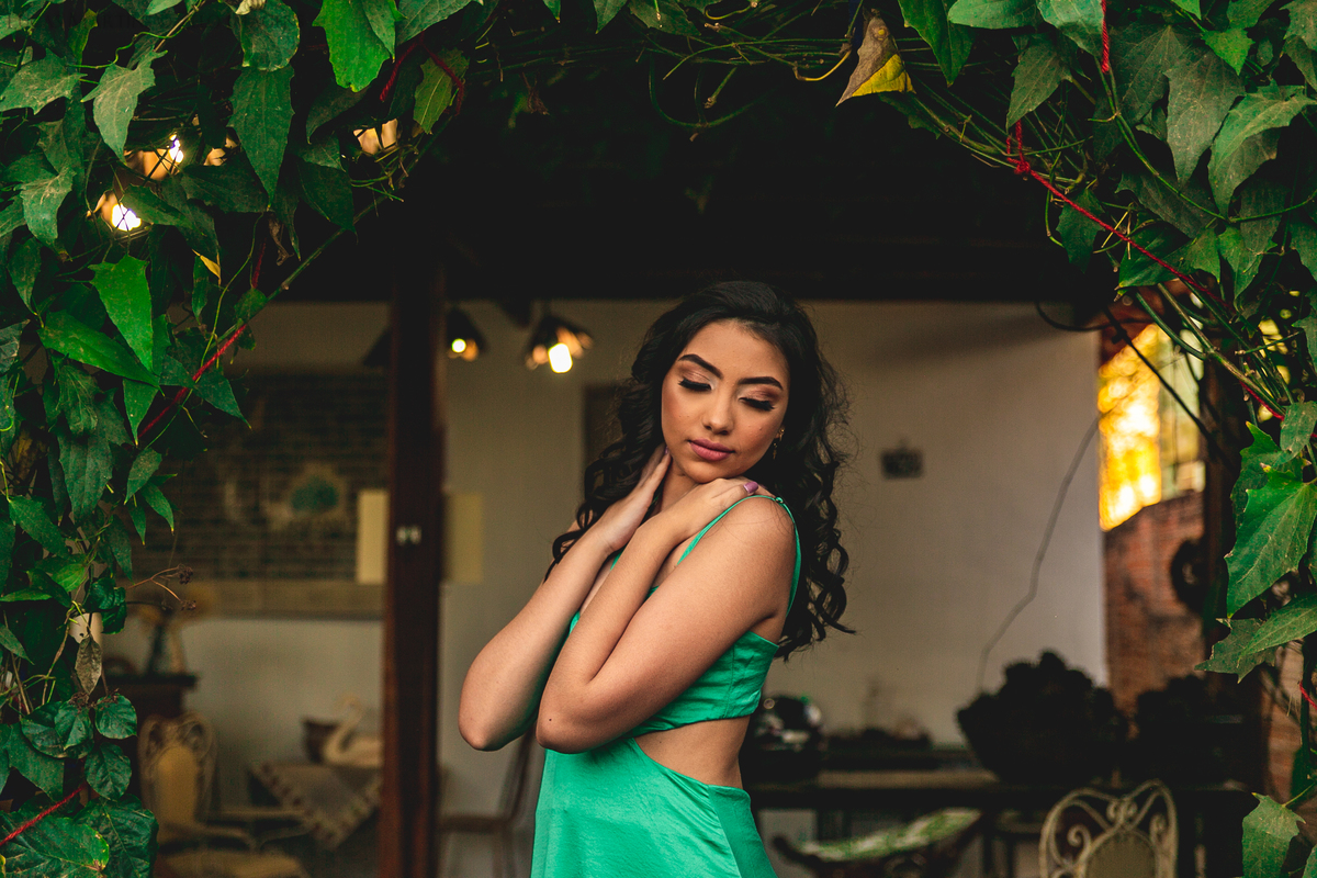 Debutante posando em um arco de folhas verdes