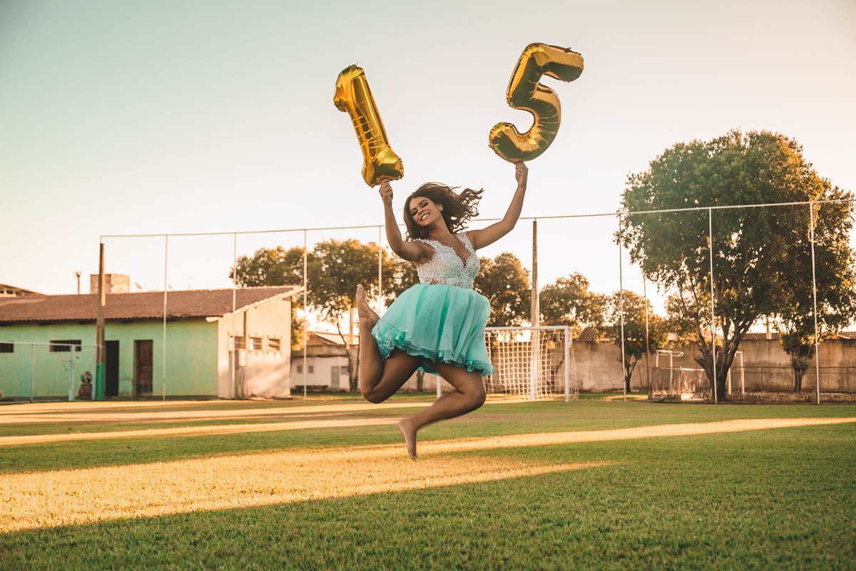 ensaio debutante saltando com o numero 15 nas maos