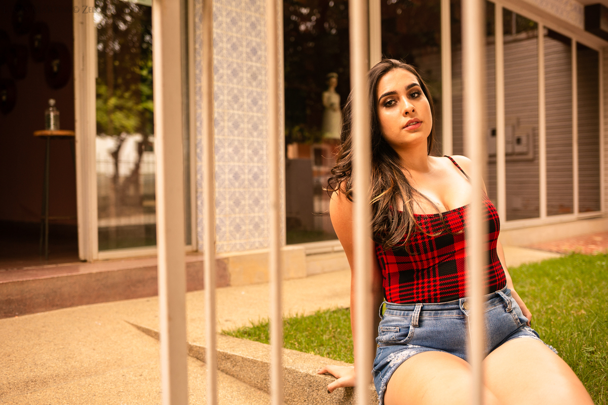 ensaio debutante entre grades com grama verde