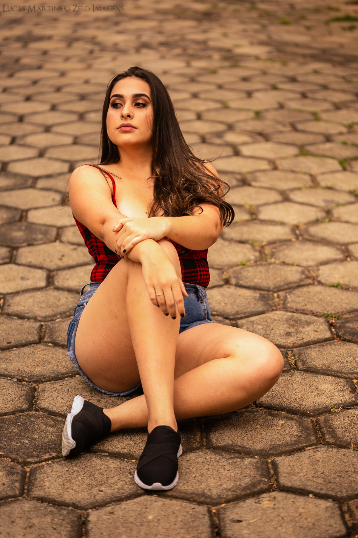 ensaio debutante sentada na rua de paralelepípedos