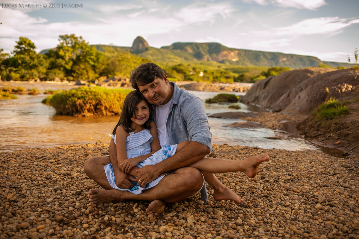 ensaio em familia pai e filha sentada na beira do rio