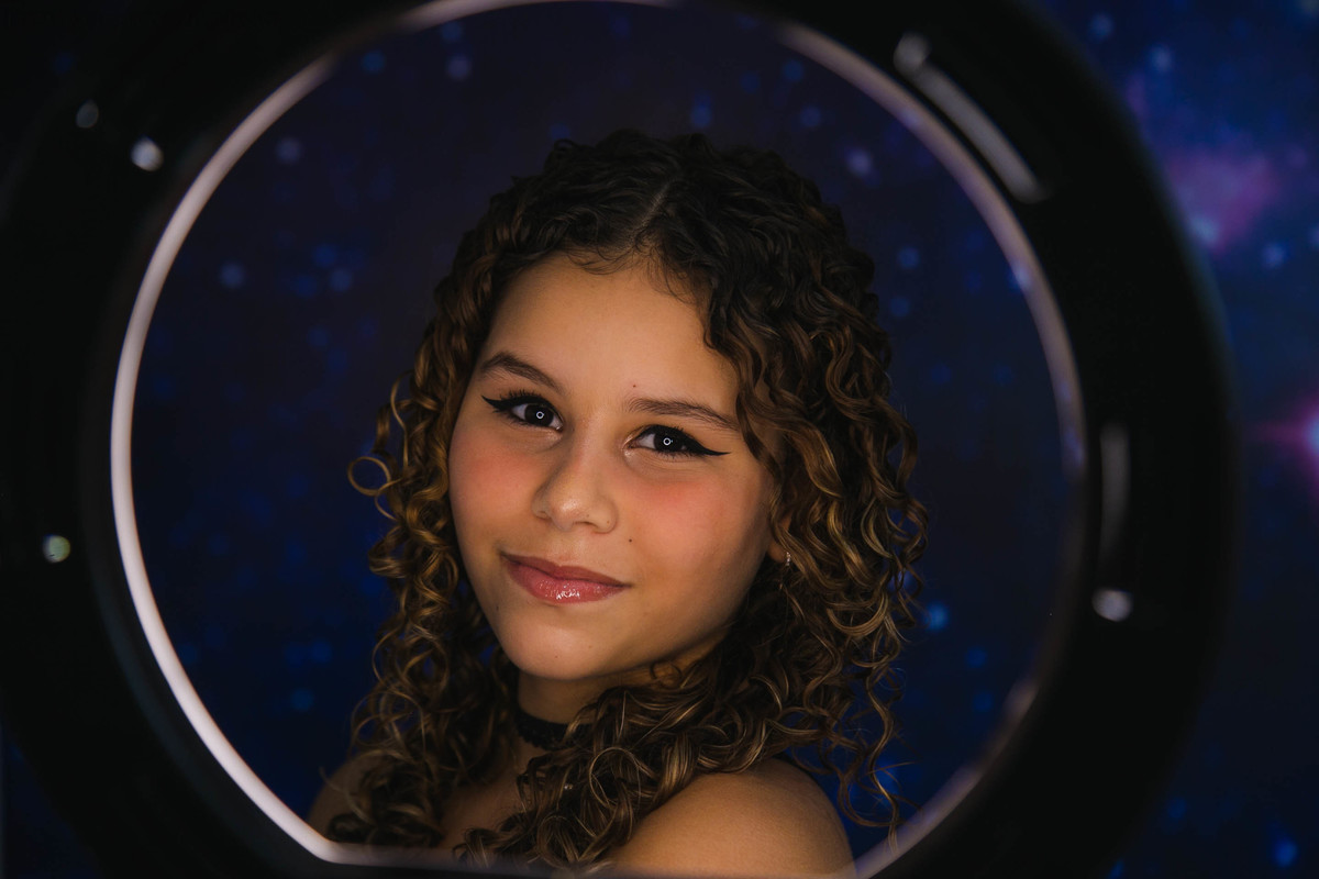 ensaio adolescente debutante maquiando em frente ao espelho com ringlight aracuai minas gerais