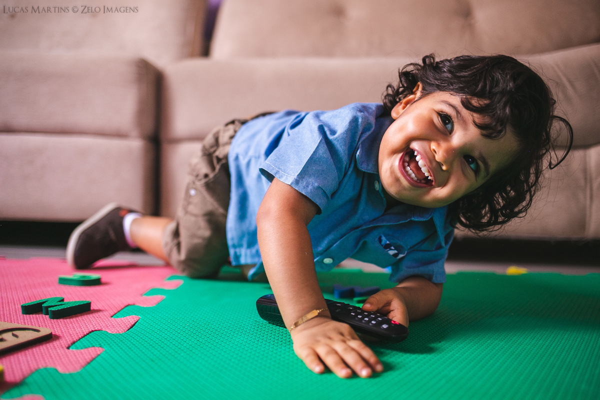 ensaio de familia em casa pandemia araçuaí mg blusa azul tapete de brinquedos controle remoto