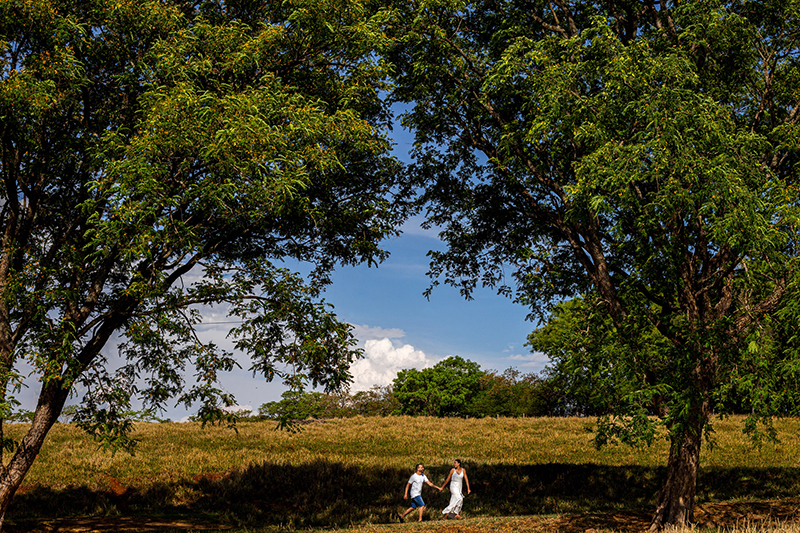 pre wedding em jau sp morro vermelho casal correndo entre as arvores