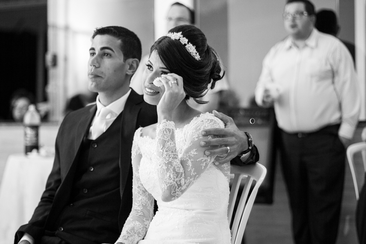 FOTOGRAFIA NOIVOS AO ASSISTIR A RETROSPECTIVA DE CASAMENTO