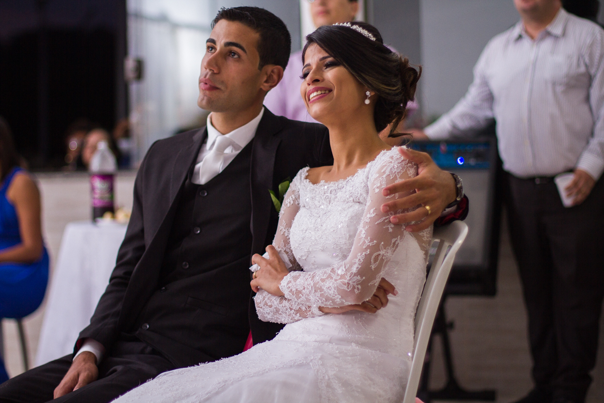 FOTOGRAFIA NOIVOS AO ASSISTIR A RETROSPECTIVA DE CASAMENTO