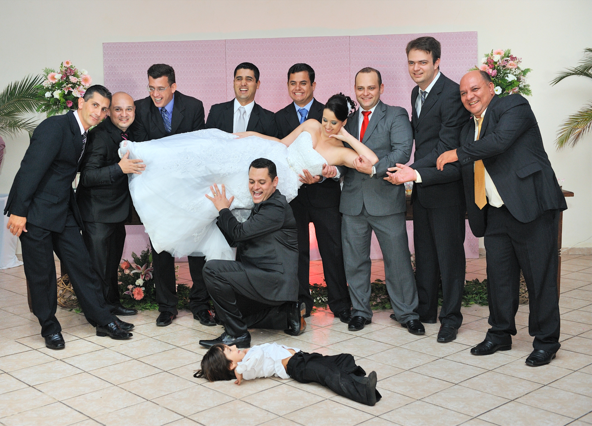 Imagine a noiva sendo carregada pelos padrinhos durante a festa de casamento onde rola muita alegria e descontração