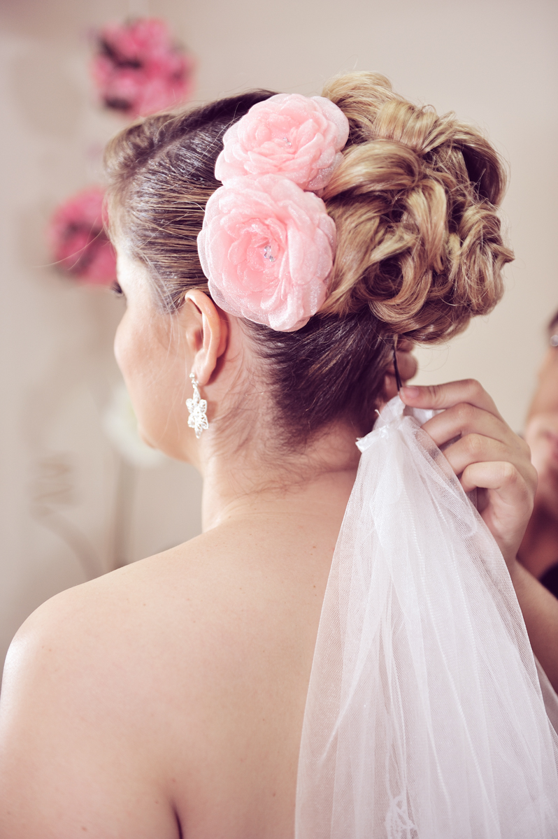 Detalhe do cabelo da noiva mostra flores rosas