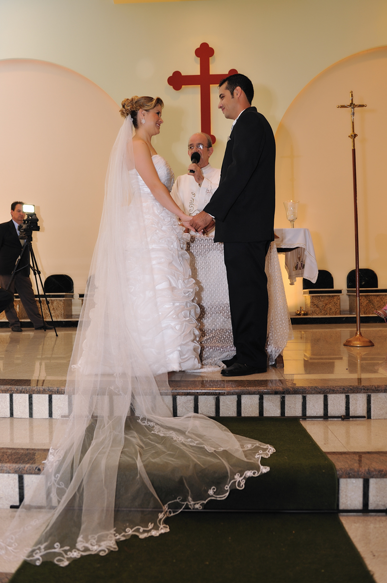 De mãos dadas os noivos se olham