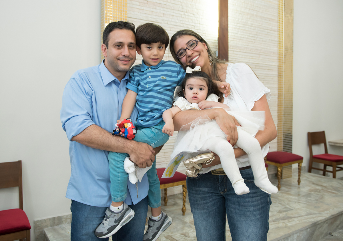pai, irmão , mãe e Carolina fazem pose para o fotógrafo de batizados em sjc com muito sorriso