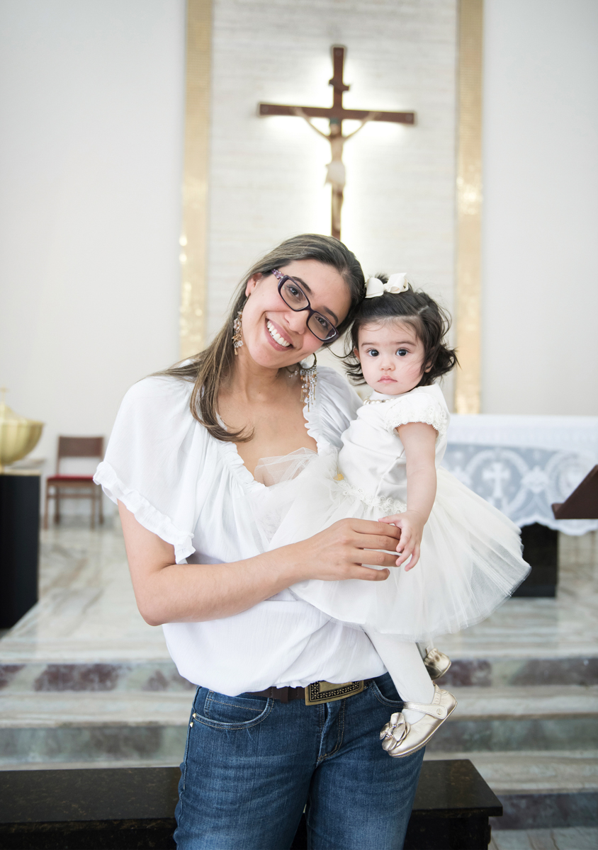 Sorridente mamãe com a filha no batizado de domingo
