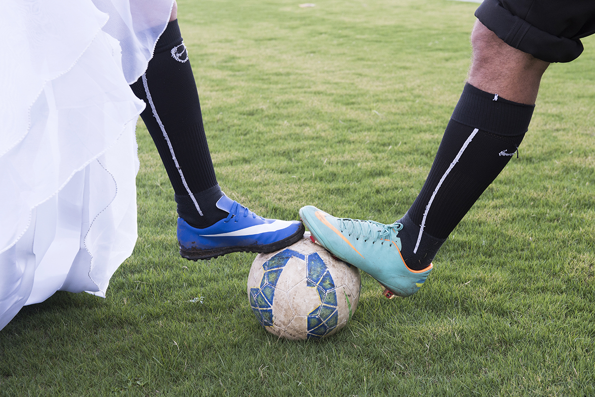 Bola de ouro em disputa do casal bem observado  pelo fotógrafo de casamento Marcio Janousek e a grama estava molhada