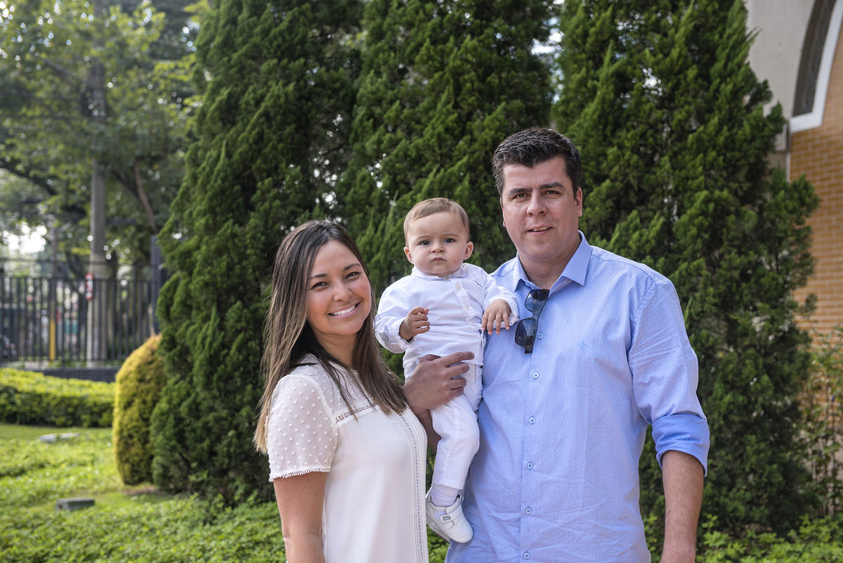 O batizando Pedro e seu pais . Deseja saber a que preço um serviço de fotógrafos para um batizado?