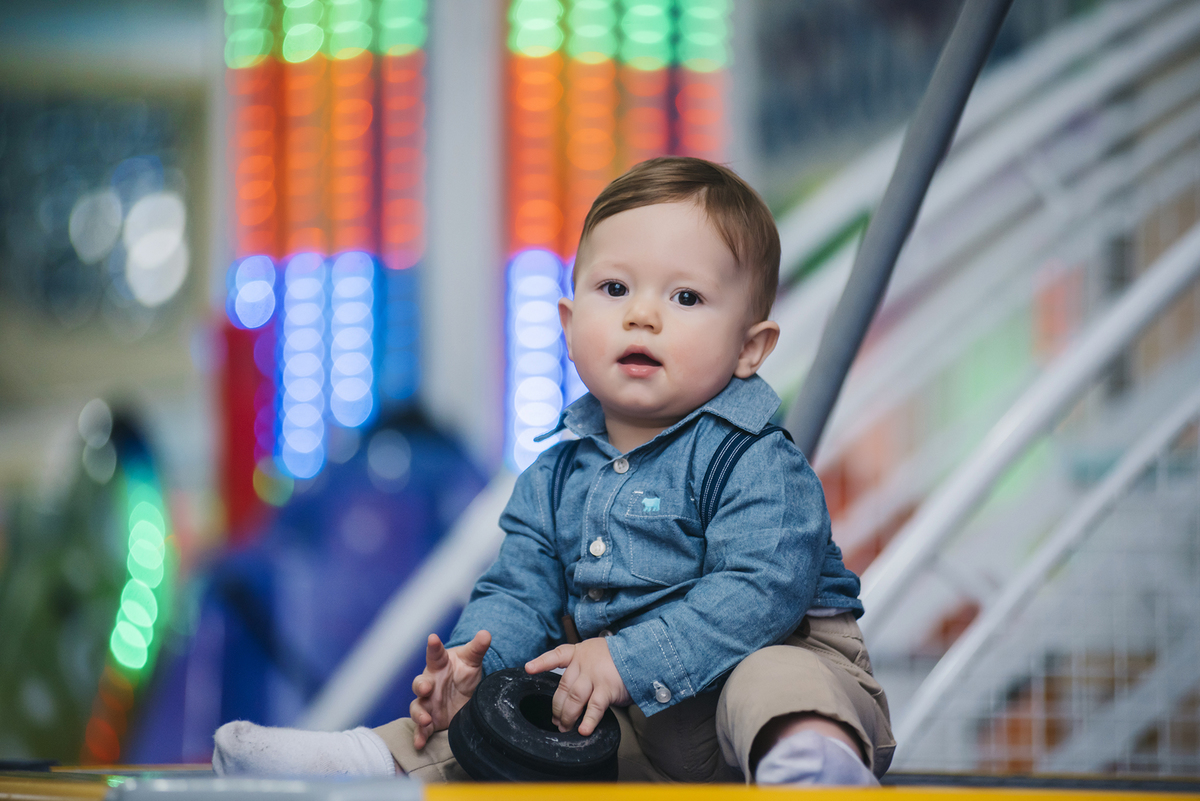 Desfoque no fundo faz destacar o aniversariante que brinca enquanto posa para foto