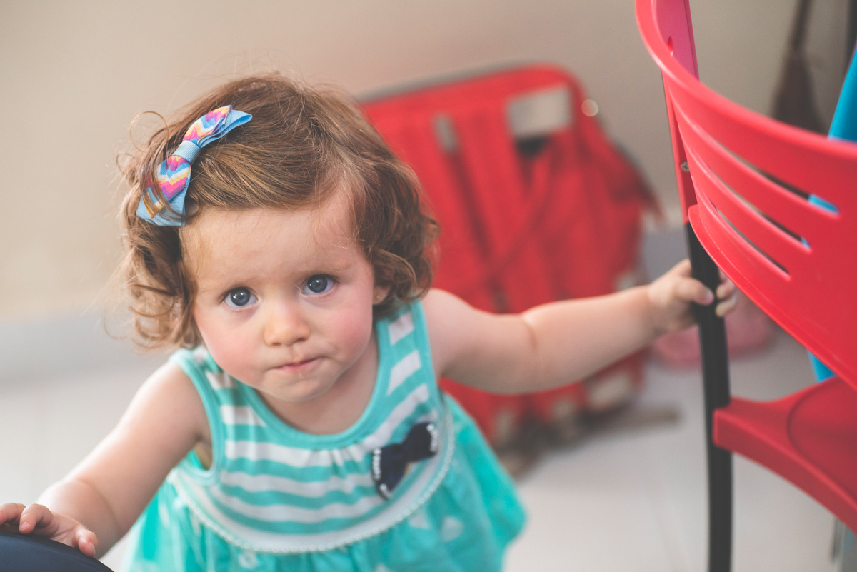 Menina bonita escalando as cadeiras vermelhas