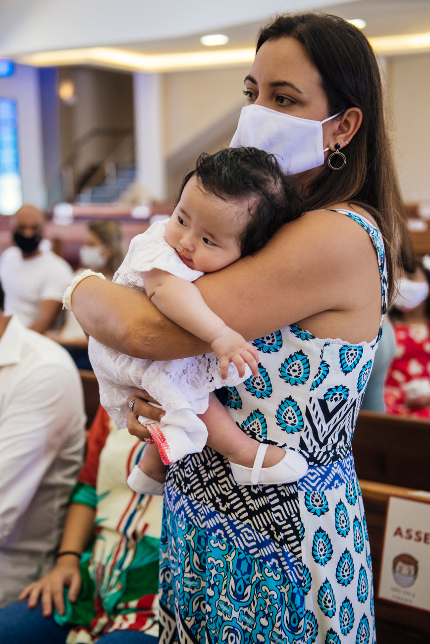 Fotos do bebê no colo da mãe, mostrando detalhes da roupinha e da interação entre os dois.