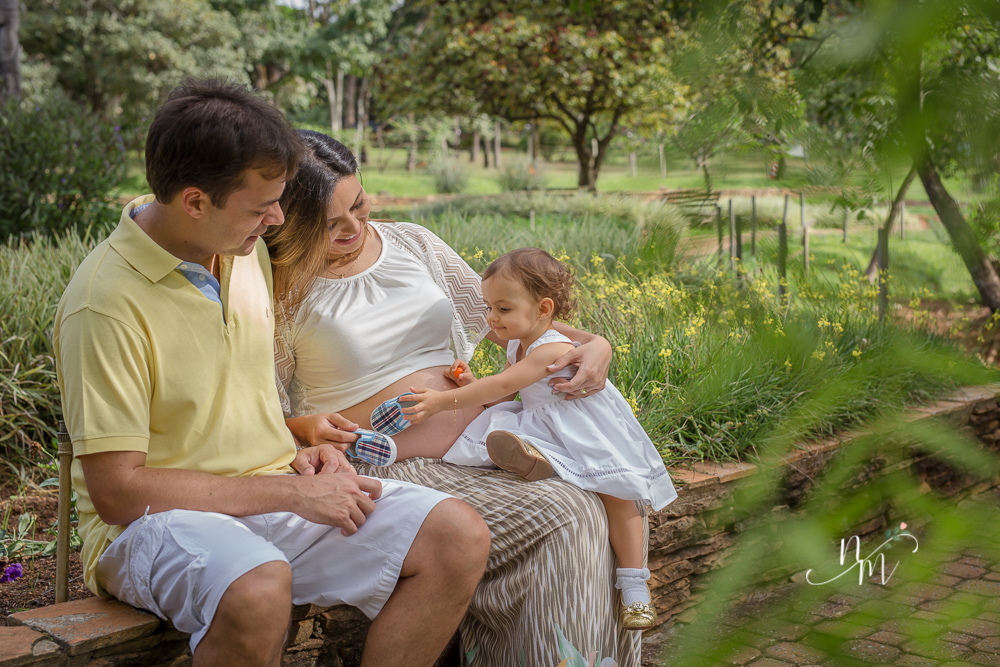 Foto tirada por Natália Melo Fotografia de uma gestante com a filha no colo em um parque em Belo Horizonte - MG