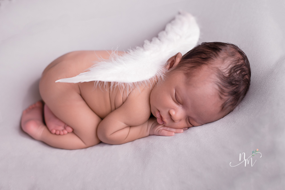 foto de bebe recem nascido deitado com asa de ajinho