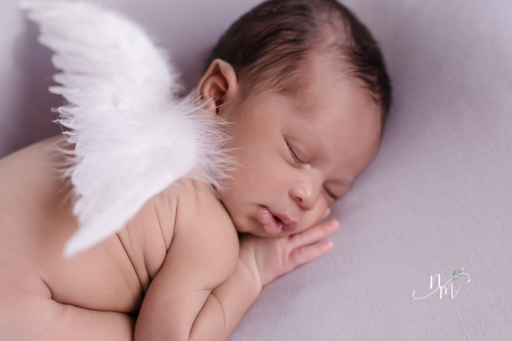 foto de bebe recem nascido deitado com asa de ajinho