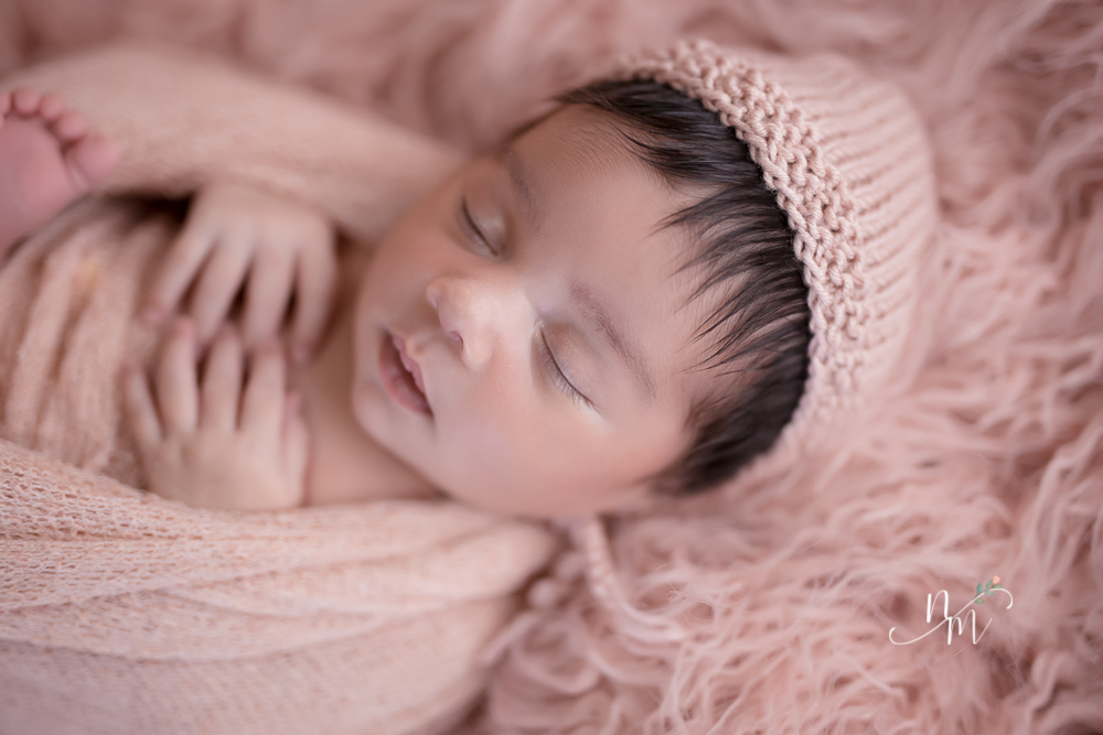 Bebê recém nascido enrolado no tecido rosa