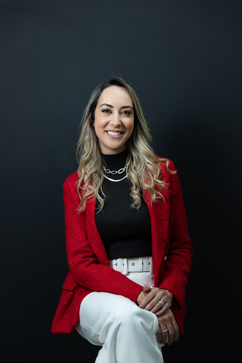 biomédica com roupa vermelha e preta no fundo preto