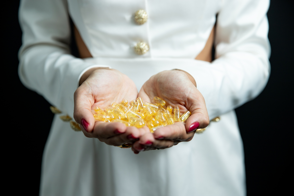 mãos de Biomédica segurando cápsulas 