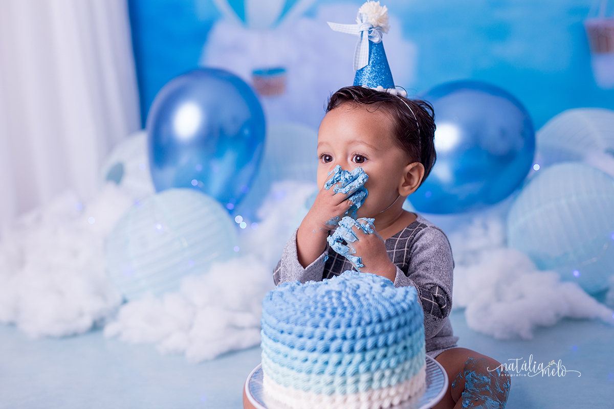 menino comendo bolo no Ensaio smash the cake no tema Balões feito no Estúdio Natália Melo Fotografia em Belo Horizonte - MG