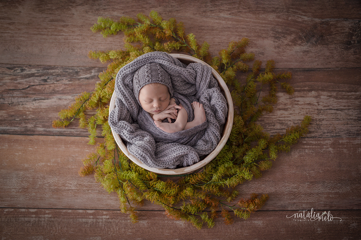 Bebê de deitado na tina redonda de madeira, no ensaio newborn em Belo Horizonte - MG no Estúdio Natália Melo Fotografia