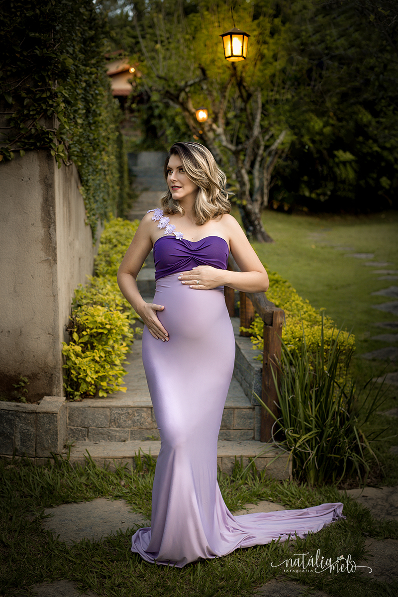 Gestante de vestido lilás com as mãos na barriga em Belo Horizonte - MG por Natália Melo Fotografia