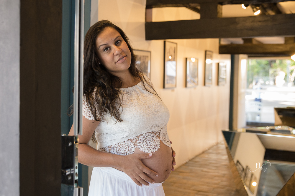 ensaio de gestante feito por Natália Melo Fotografia em Belo Horizonte -MG, no Museu Histórico Abílio Barreto, onde a Flaviana está encostada numa porta de vidro