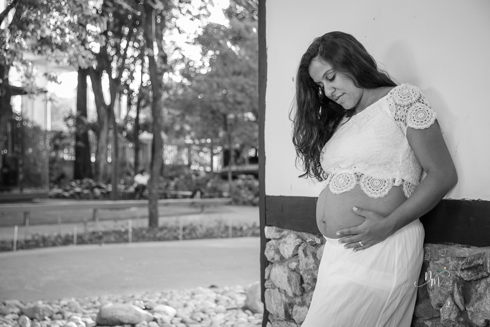 ensaio de gestante feito por Natália Melo Fotografia em Belo Horizonte -MG, no Museu Histórico Abílio Barreto, onde a Flaviana está encostada na parede olhando para a barriga