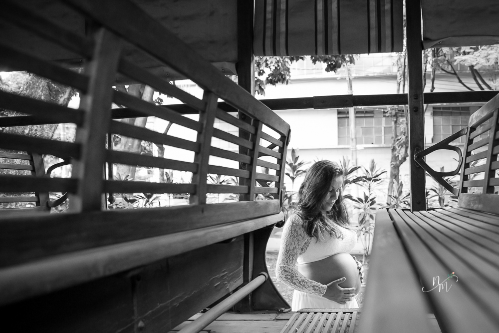 ensaio de gestante feito por Natália Melo Fotografia em Belo Horizonte -MG, no Museu Histórico Abílio Barreto, onde a Flaviana entre os bancos de um bonde ohando para a barriga