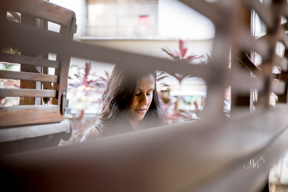 ensaio de gestante feito por Natália Melo Fotografia em Belo Horizonte -MG, no Museu Histórico Abílio Barreto, onde a Flaviana entre os bancos de um bonde ohando para a barriga