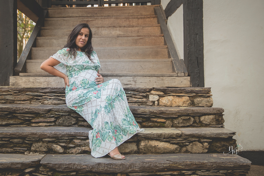 ensaio de gestante feito por Natália Melo Fotografia em Belo Horizonte -MG, no Museu Histórico Abílio Barreto, onde a Flaviana está sentada em uma escadaria de pedras