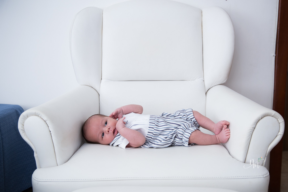Ensaio de Newborn feito por Natália Melo Fotografia em Belo Horizonte - MG, onde ele está deitado na poltrona de amamentação