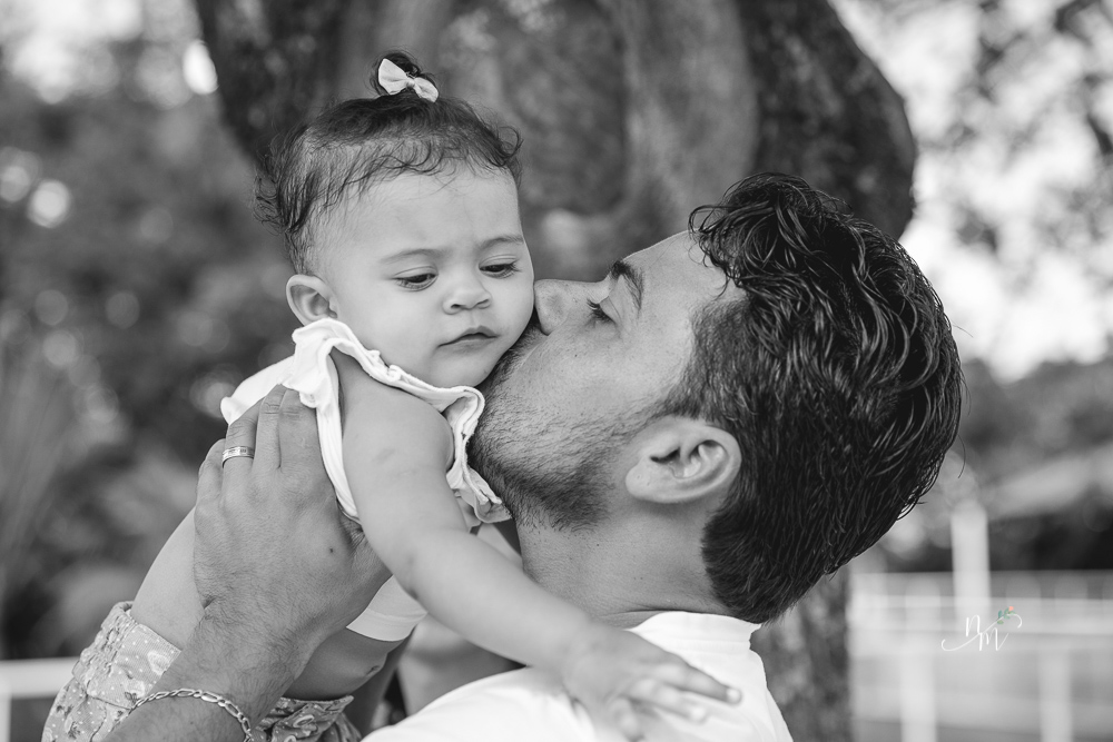 Ensaio de Família feito por Natália Melo Fotografia no Clube Jaraguá em Belo Horizonte - MG, onde o pai carrega Lara no colo e dá um beijo