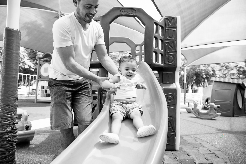Ensaio de Família feito por Natália Melo Fotografia no Clube Jaraguá em Belo Horizonte - MG, onde Lara brinca no escorregador com o pai