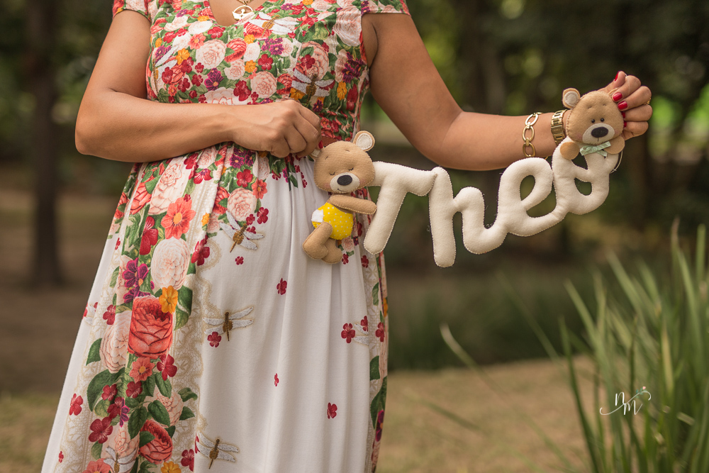 Gestante com uma plaquinha com o nome do bebê em uma área verde em Belo Horizonte  - MG fotografada por Natália Melo