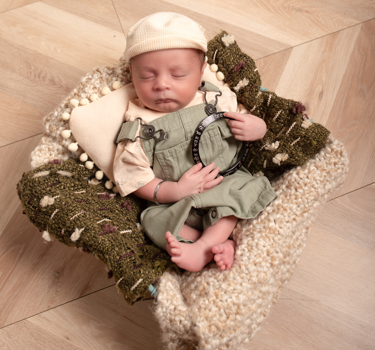 Newborn baby boy posed safely in father’s hands – Burnaby newborn photography studio
