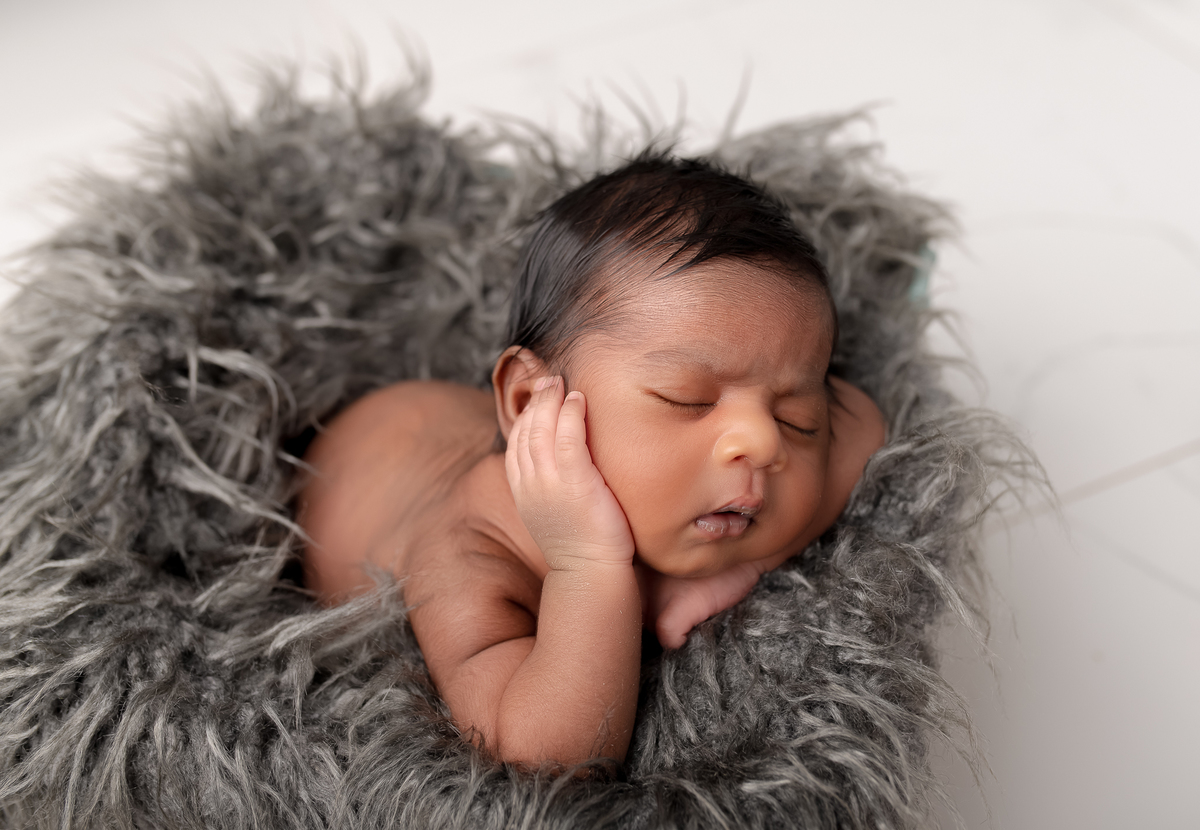Newborn baby boy posed safely in father’s hands – Burnaby newborn photography studio
