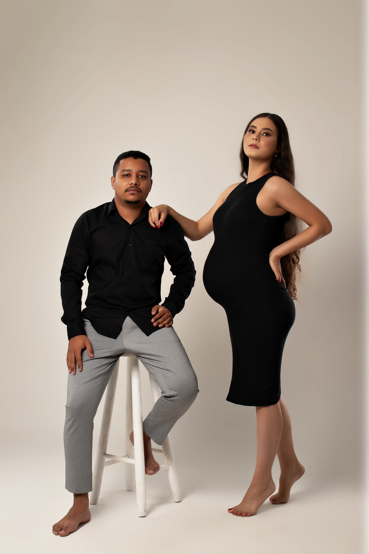 ensaio gestante em estúdio clean conceito vestido longo poltrona pose preto e branco com marido estúdio marcos felipe fotografia barreiro belo horizonte bh mg contagem ibirite
