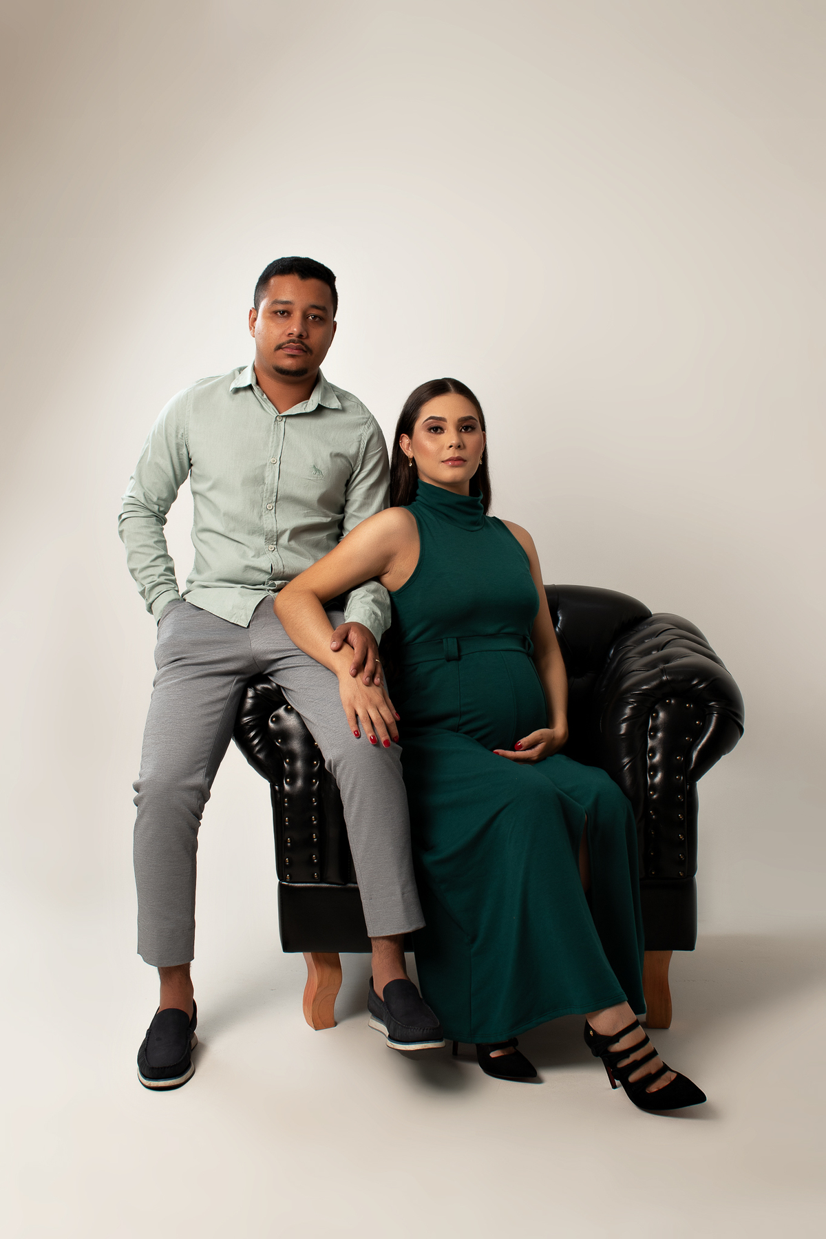 ensaio gestante em estúdio clean conceito vestido longo poltrona pose preto e branco com marido estúdio marcos felipe fotografia barreiro belo horizonte bh mg contagem ibirite