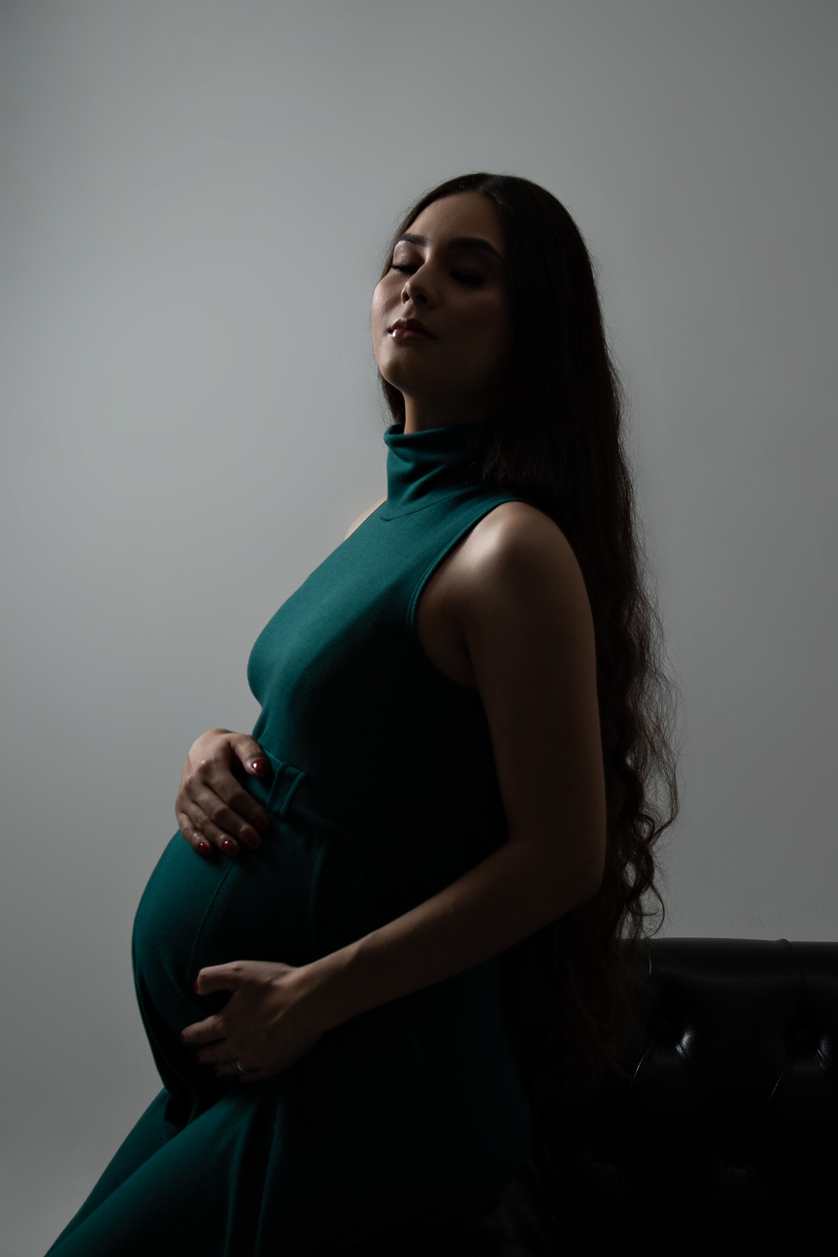 ensaio gestante em estúdio clean conceito vestido longo poltrona pose preto e branco com marido estúdio marcos felipe fotografia barreiro belo horizonte bh mg contagem ibirite