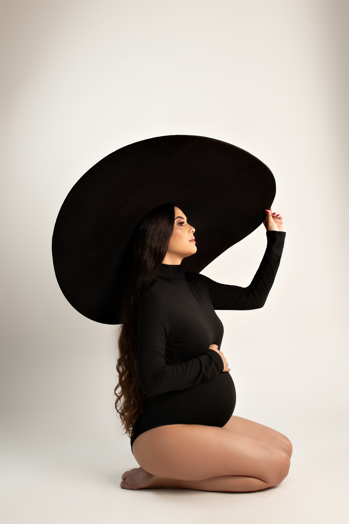 ensaio gestante em estúdio clean conceito vestido longo poltrona pose preto e branco com marido estúdio marcos felipe fotografia barreiro belo horizonte bh mg contagem ibirite