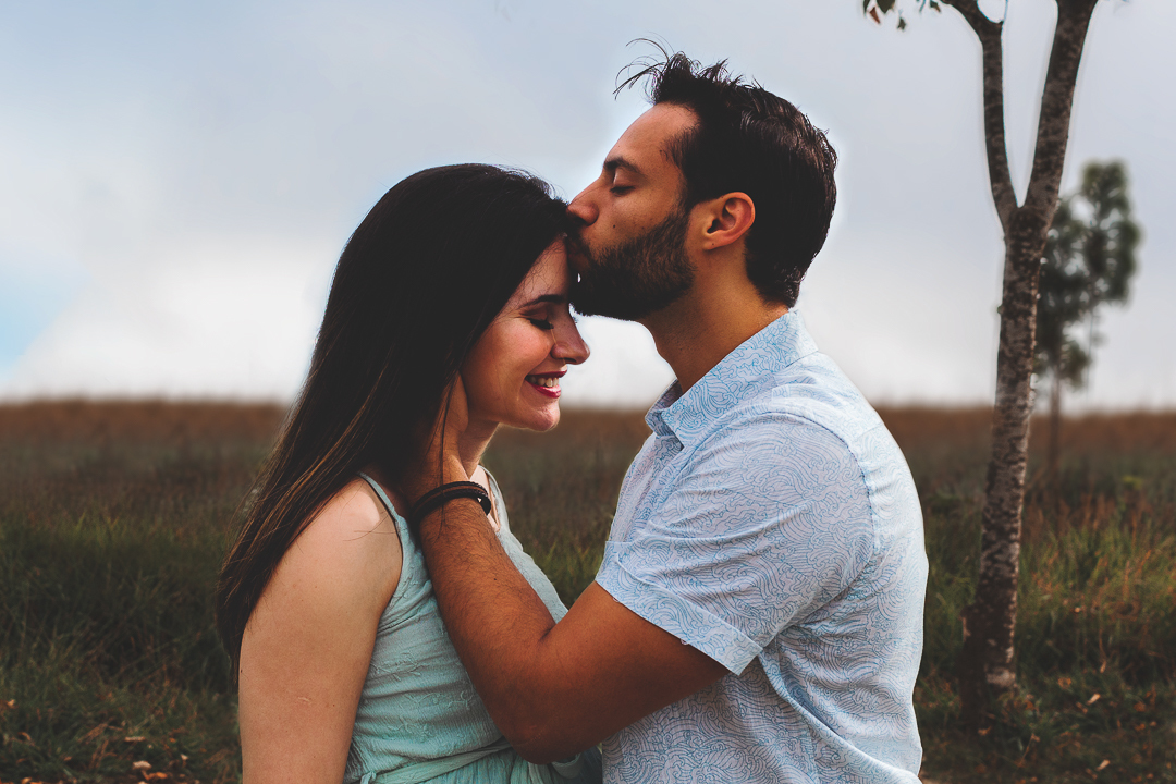 casal gestante, marido beijando a testa da mulher
