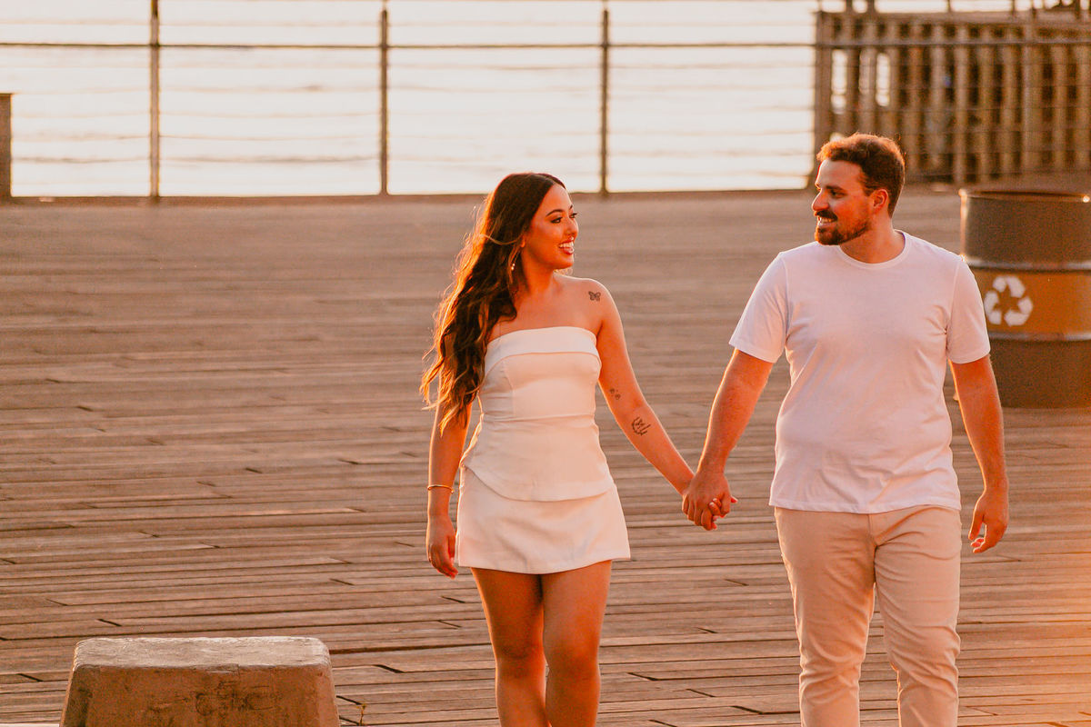 Casal caminhando à beira do Guaíba durante ensaio de pré casamento.