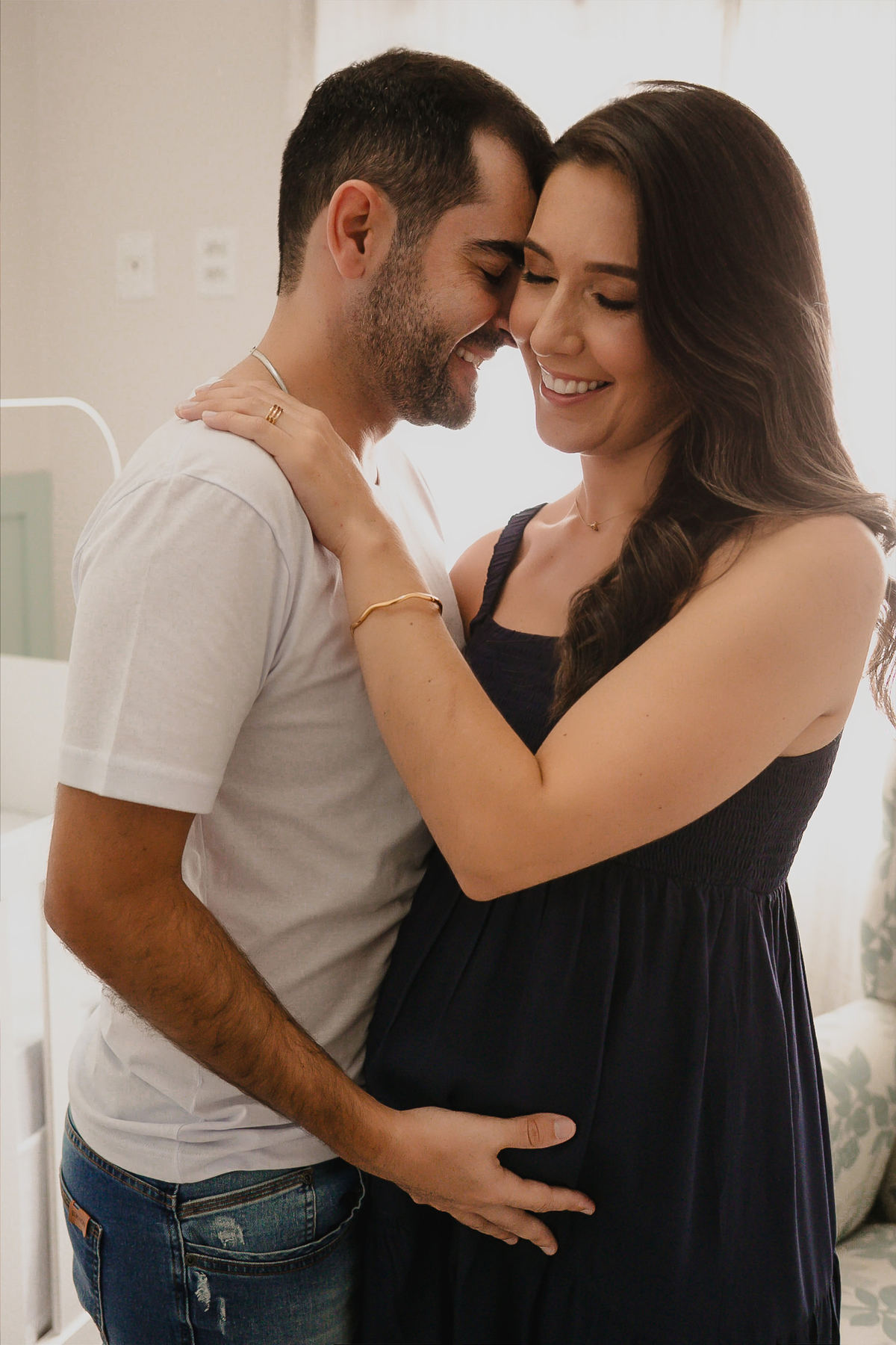 Fotos de gestante e casal em casa registrando momentos espontâneos e cheios de significado.