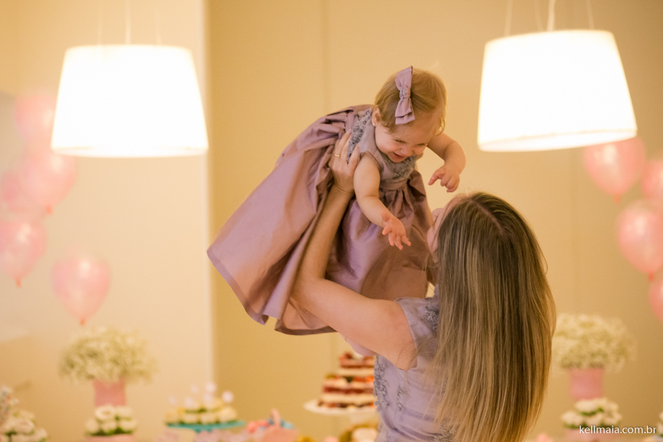 mamãe levanta a menina na festa