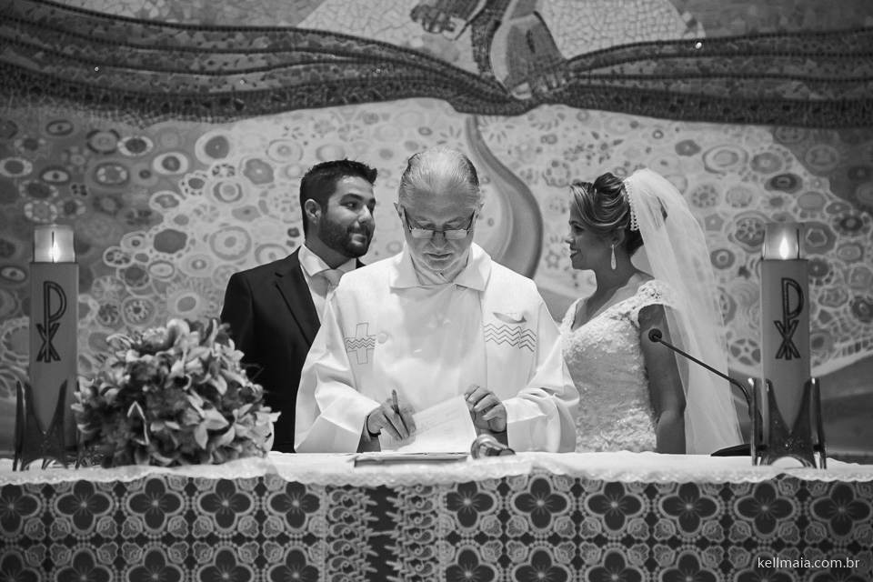 padre assinando e noivos conversando